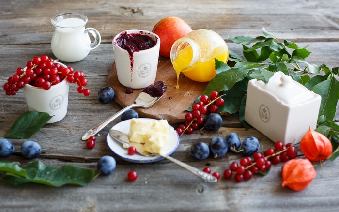 Still life with berries, plums, honey, and milk