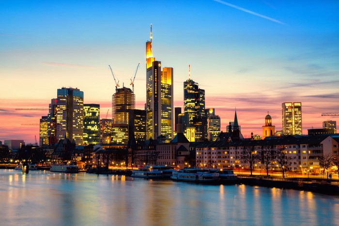 Frankfurt skyline at dusk with river and boats