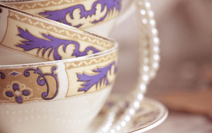 Stack of teacups with pearl necklace