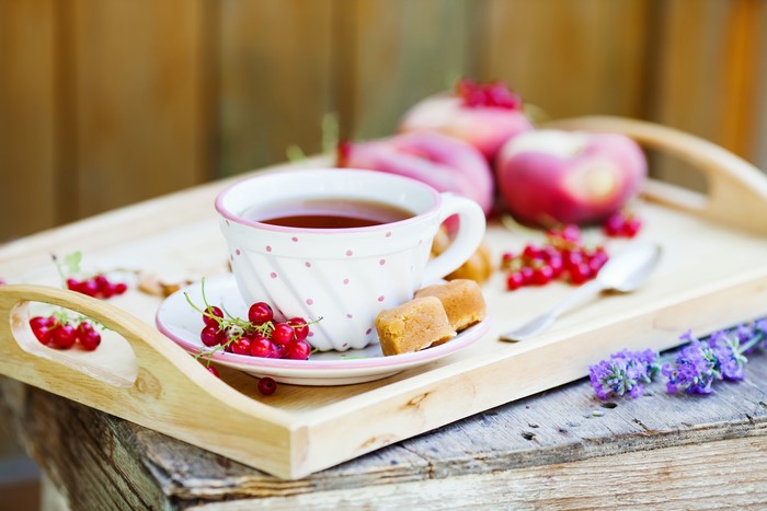Tea with currants and peaches on a tray