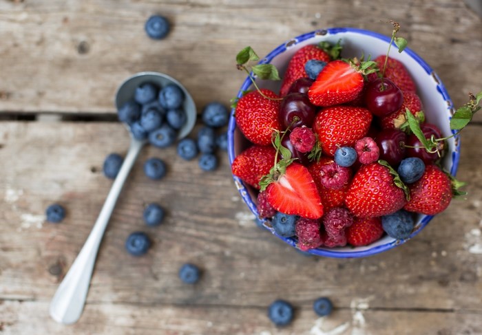 Bowl of Strawberries, Blueberries, and Cherries with Spoon