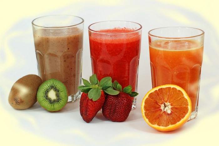 Three glasses of juice with fruits
