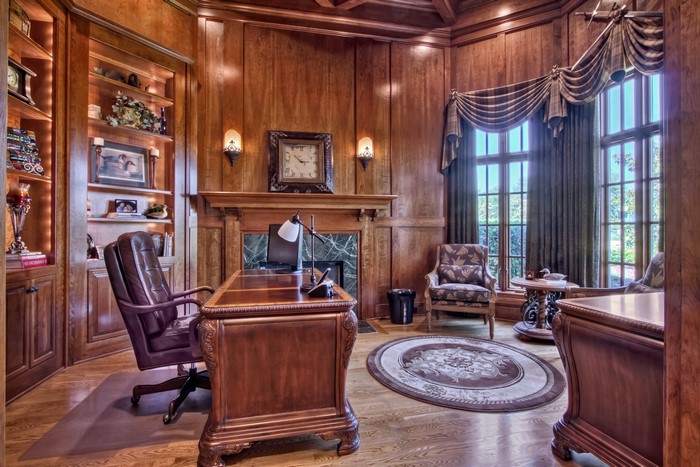 Luxurious wooden office with fireplace and armchair