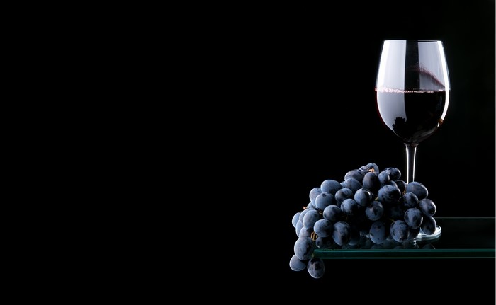 Red wine in a glass with grapes