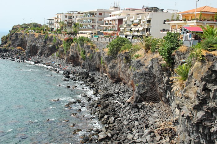 Aci Castello, Sicily, Italy coast with rocky cliffs and buildings