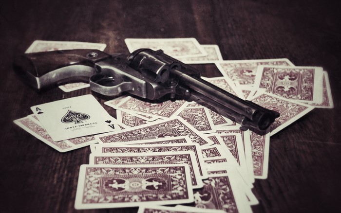 Revolver on a pile of playing cards