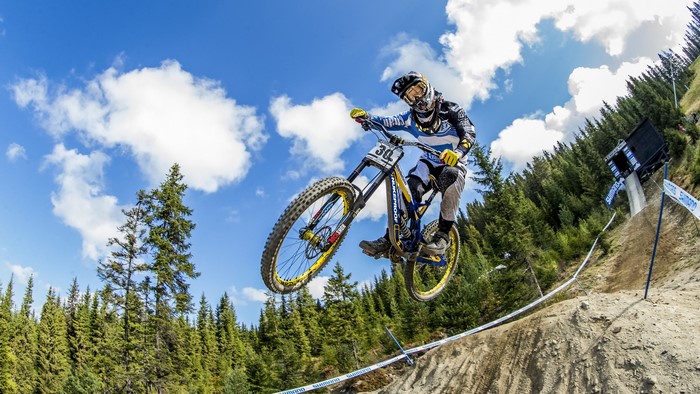Mountain biker jumping over a dirt ramp