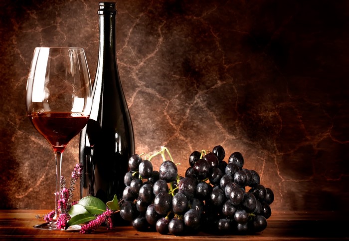 Wine bottle, glass of red wine, and grapes