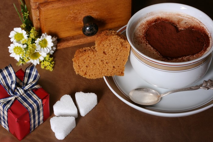 Heart-shaped cocoa with cake and gift