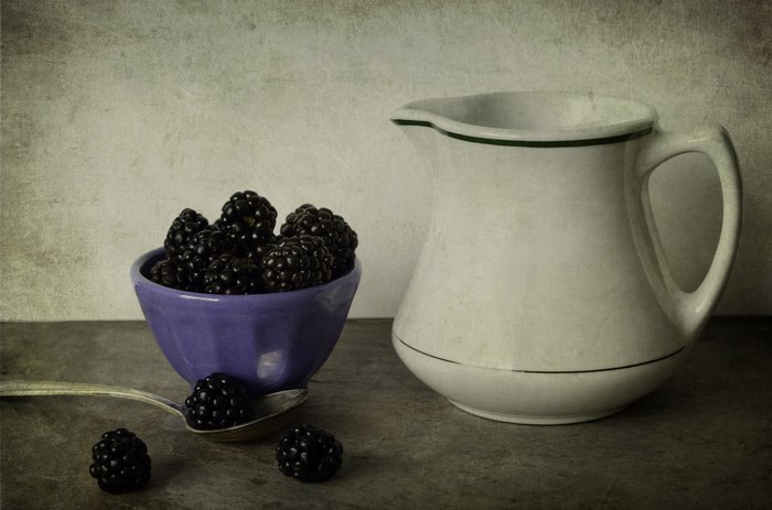 Blackberries in a bowl with a pitcher
