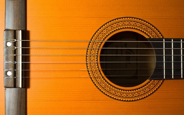 Closeup of a classical guitar's soundhole and strings