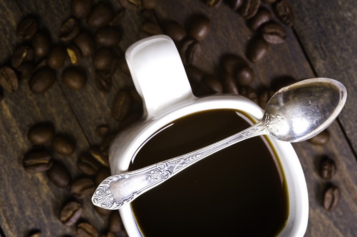 Coffee cup with spoon and beans