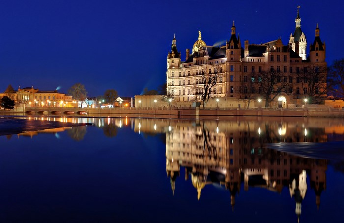 Schwerin Castle reflected in water at night