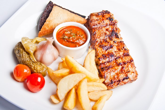Grilled meat with fries and pickles