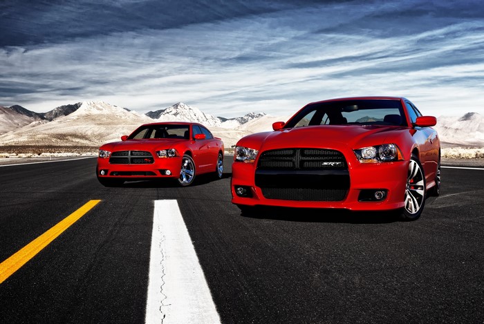 Two red Dodge Charger SRT8 cars on asphalt road