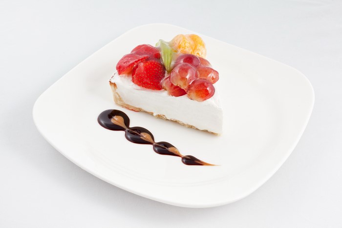 Slice of fruit tart with chocolate drizzle