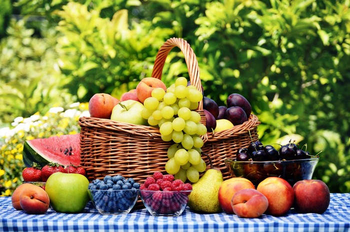 Fruit in a wicker basket with a checkered tablecloth