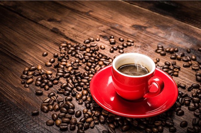 Hot Coffee in a Red Cup on a Saucer with Coffee Beans