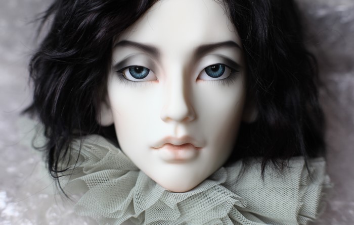 Close-up of a doll's face with blue eyes