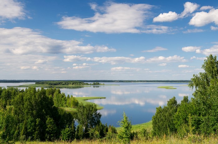 Lake Snudy in Latvia under a cloudy blue sky