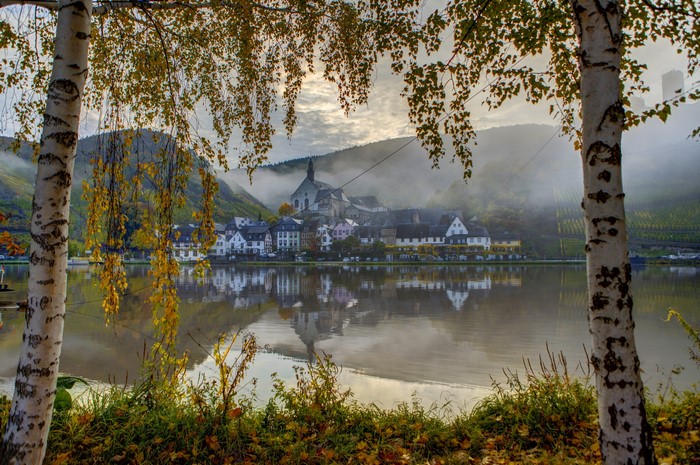 Village on a river in fog, Germany