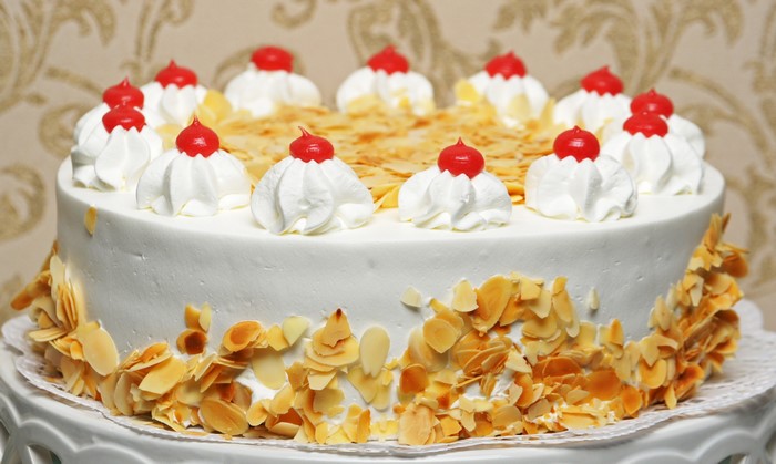 White cake with whipped cream and cherries