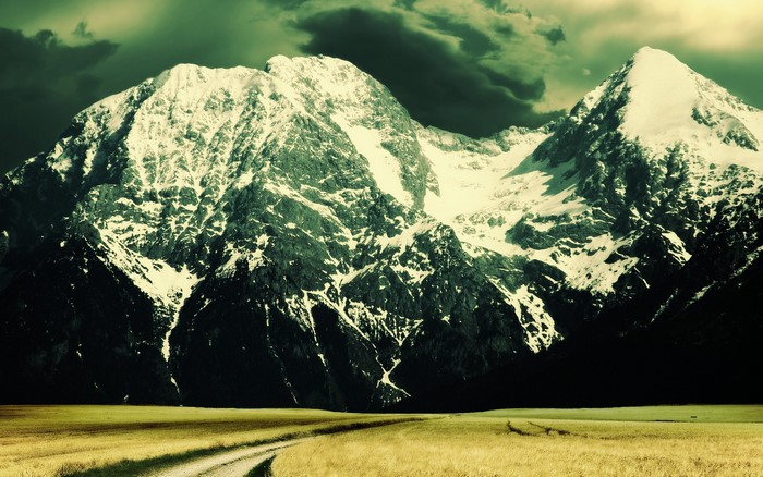 Snow-capped mountains under a dark sky