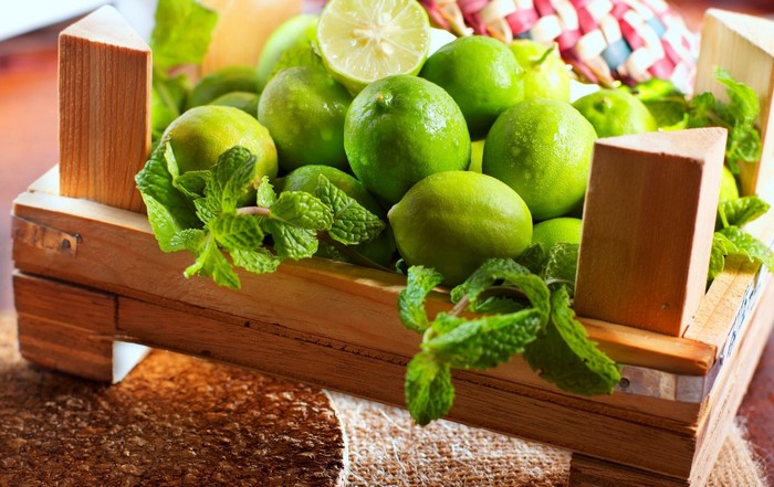 Limes and mint in a wooden crate