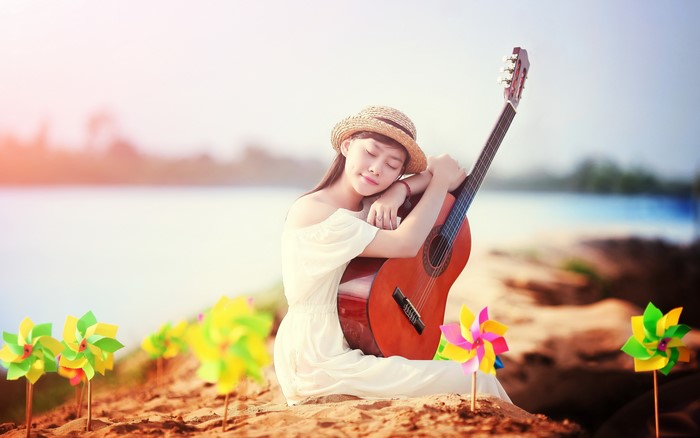 Asian girl with guitar on beach