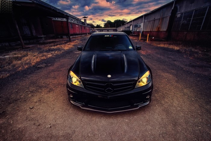 Black Mercedes-Benz C63 AMG parked on dirt road
