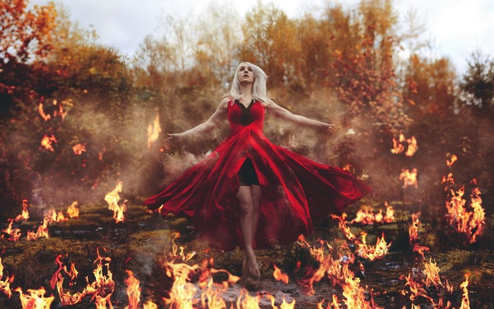 Woman in red dress surrounded by fire