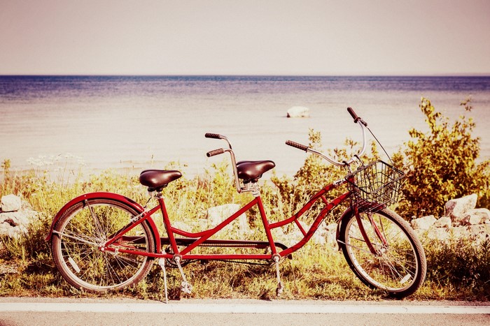 Red tandem bicycle by the water