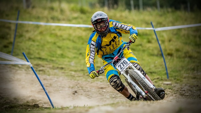 Downhill mountain biker in yellow and blue gear