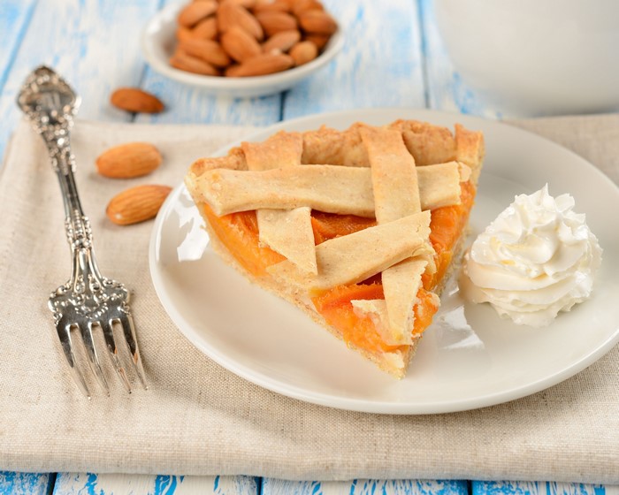 Slice of pie with almonds and whipped cream