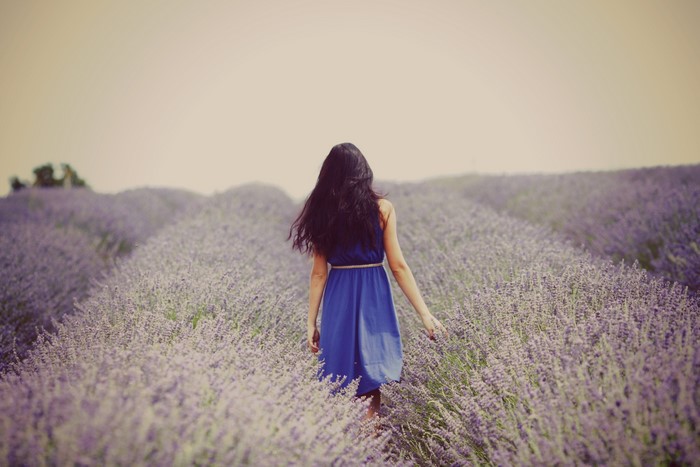 Woman in blue dress walking through lavender field