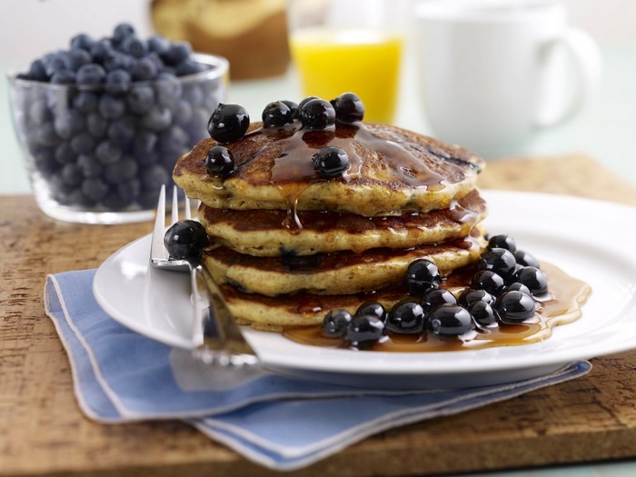 Stack of blueberry pancakes with syrup and blueberries