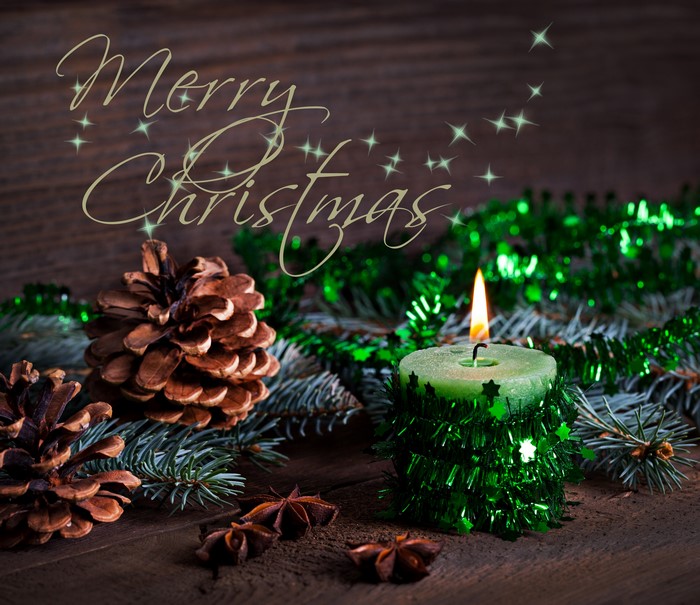 Merry Christmas candle with pine cones and fir branches