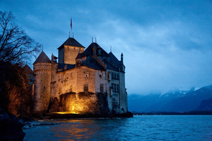 Chillon Castle on a lake in Switzerland at dusk