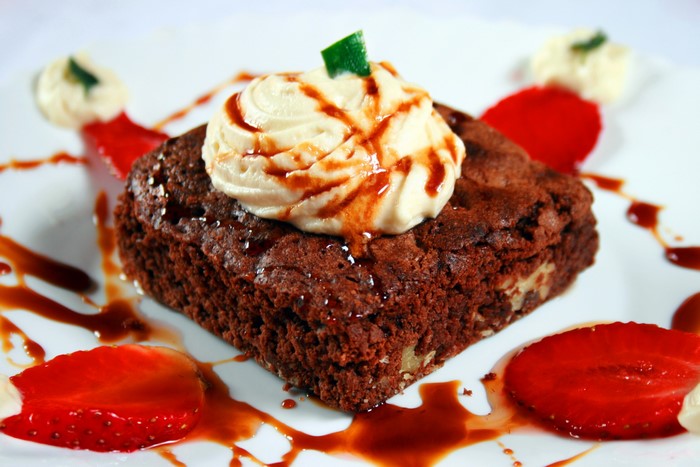 Chocolate brownie with whipped cream and strawberries