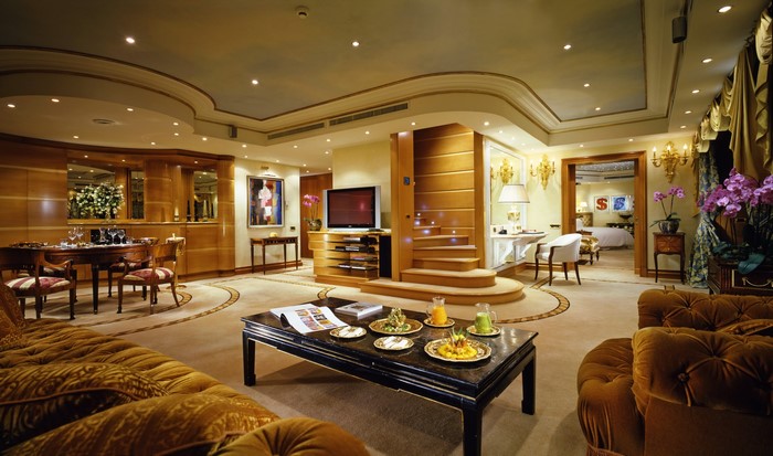 Luxury hotel suite living room with dining area and bedroom