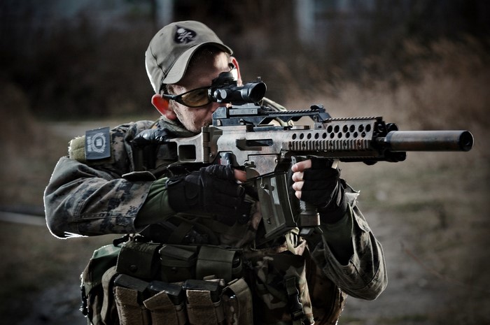 Soldier aiming a rifle with a scope