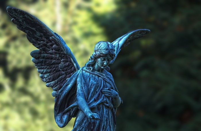A weathered angel statue with wings outstretched