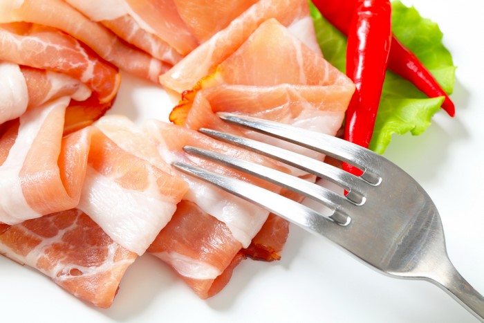 Ham with chili peppers and fork