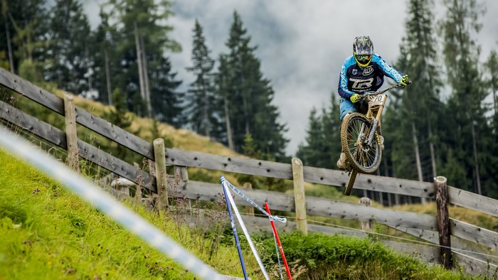 Mountain biker jumping over a wooden fence