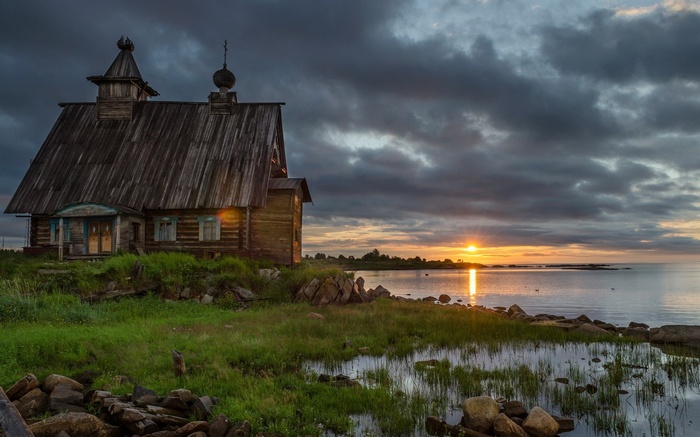 Wooden church by the sea at sunset