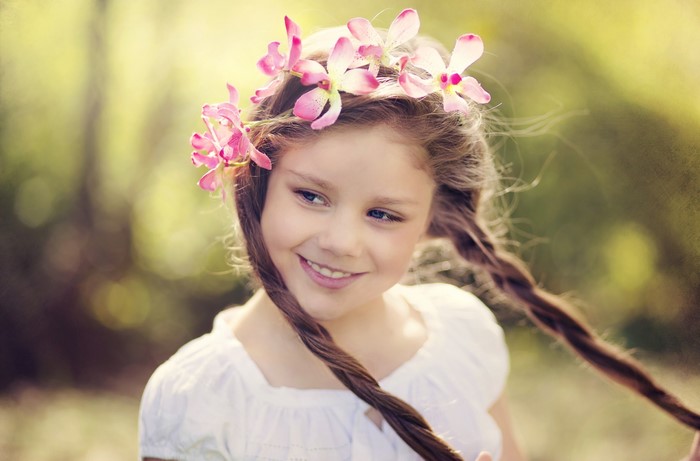 Girl with flower crown and braided hair smiling
