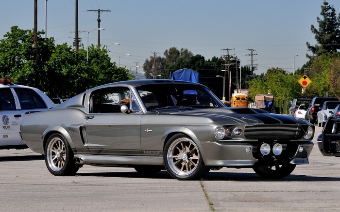 Grey Ford Mustang GT500 parked next to a police car