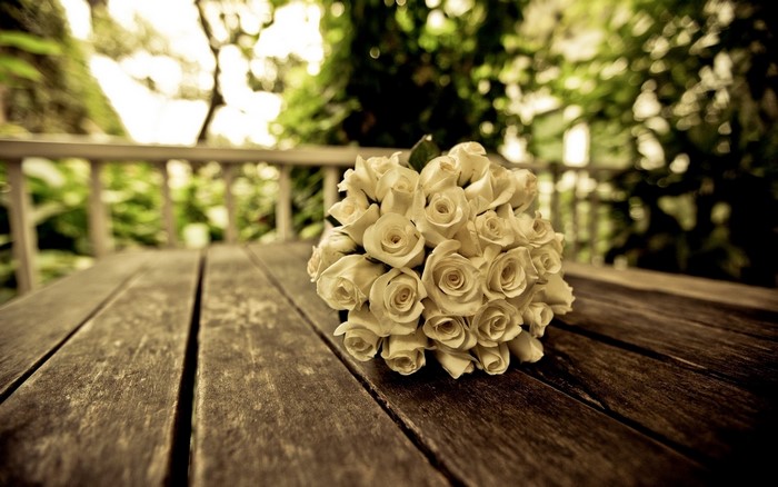 White roses bouquet on wooden table