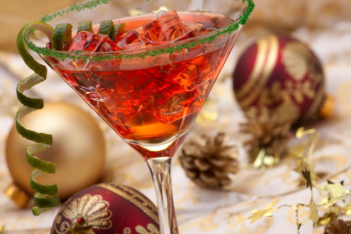 Red cocktail in a martini glass with Christmas decorations