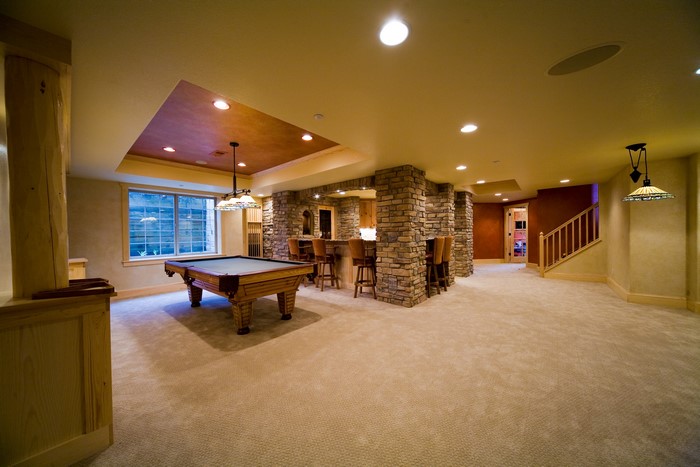 Interior of a basement with a pool table and bar